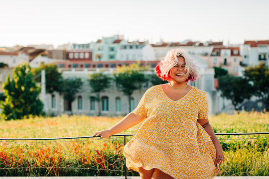 Cheerful body positive woman standing at park in city