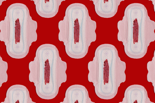 Pattern of bloodstained sanitary pads against red background