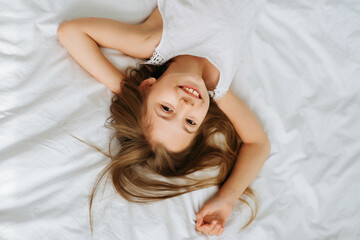 Little naughty cheerful girl schoolgirl in the morning in a bright room on a white background...