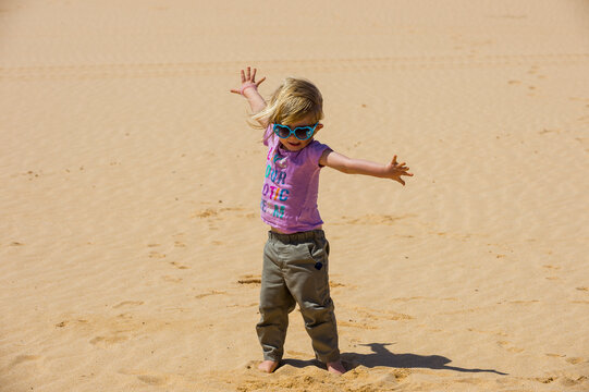 Spain, Canary Islands, Fuerteventura, Parque Natural de Corralejo, playful girl in sand dunes