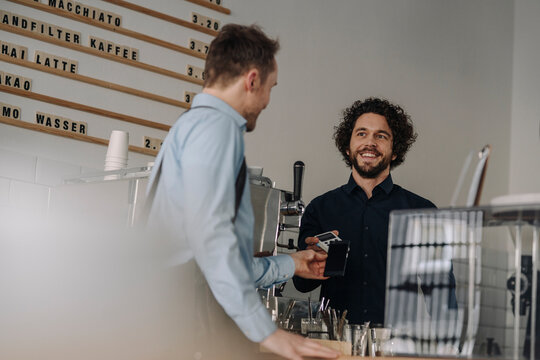 Customer paying contactless in a coffee shop