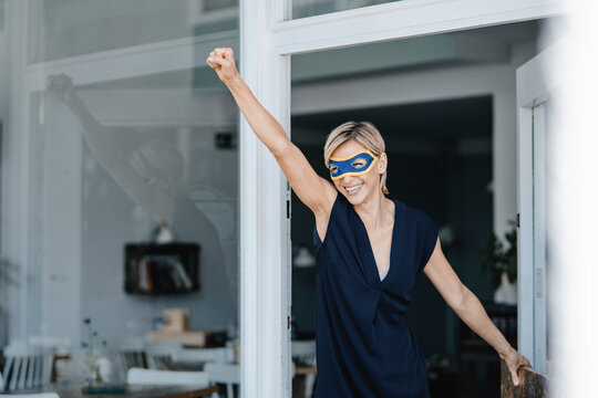 Businesswoman wearing super hero masks, pretending to fly