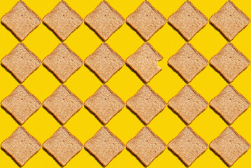 Pattern of slices of wheat bread against yellow background