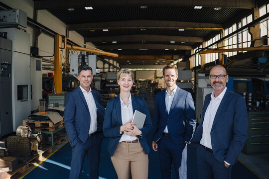 Portrait of confident business team standing in a factory
