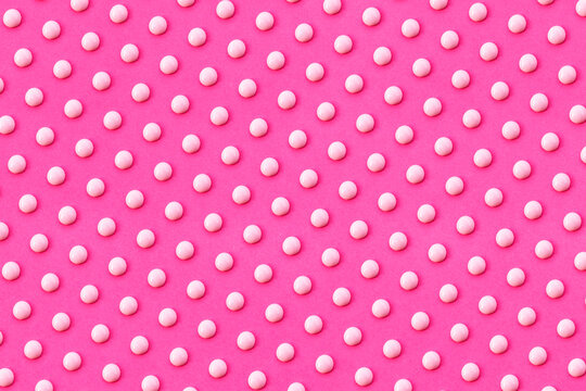 Pattern of white liquid drops against vibrant pink background