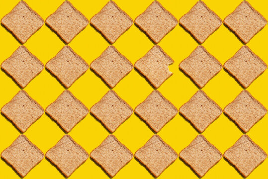 Pattern of slices of wheat bread against yellow background