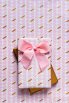 Two wrapped gifts against wrapping paper background