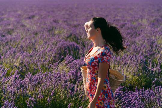 Portrait of beautiful woman standing in vast lavender field with hand in hair