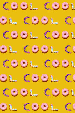 Pattern of doughnuts, marshmallows and sugar sprinkles arranged into single repeated word