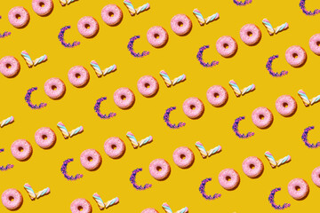 Pattern of doughnuts, marshmallows and sugar sprinkles arranged into single repeated word