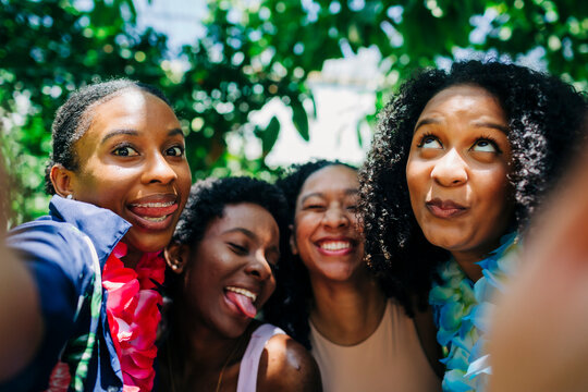 Cheerful friends taking selfie at park