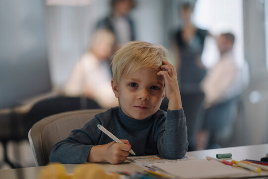Portrait of boy painting in office