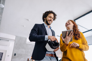 Happy businessman and businesswoman with VR glasses and tablet in office