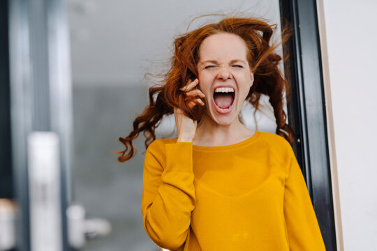 Screaming woman with windswept hair in office