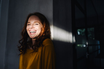Portrait of laughing redheaded woman with light and shadow