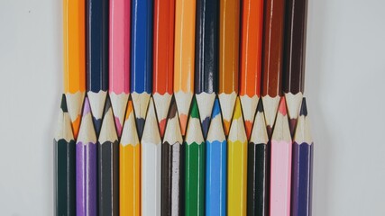 Many colored pencils are arranged around the edges of the image as a frame. In the center is an...