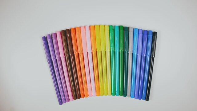 Many colored pencils are arranged around the edges of the image as a frame. In the center is an empty background with space for text. Mock up with copy space.