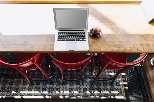 Laptop and cup of coffee on table in a cafe