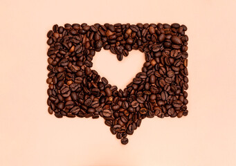 Roasted coffee beans arranged into shape of heart inside online chat bubble