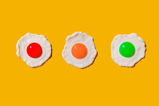 Studio shot of three colorful fried eggs