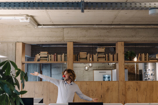 Businessman with red clown nose in office