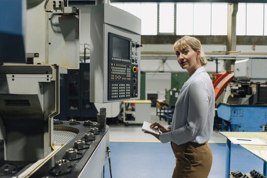 Portrait of a confident businesswoman using wireless keyboard in a factory