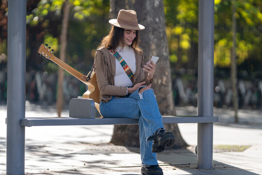 Young woman using smart phone at bus stop