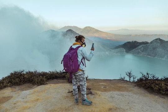 Man with respirator maskstanding at the edge of volcano Ijen, Java, Indonesia