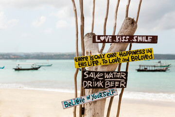 Indonesia, Bali, Jimbaran, Sign with motivational quotes standing on coastal beach
