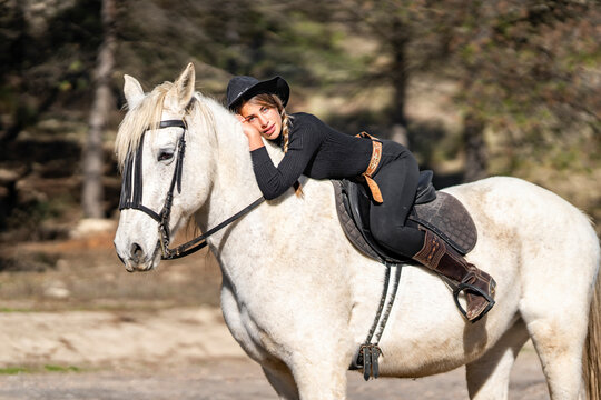Portrait of woman horseback riding in paddock