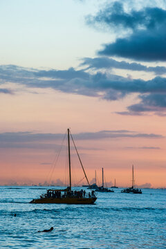 Hawaii, Oahu, Waikiki beach, sailing boats at dusk