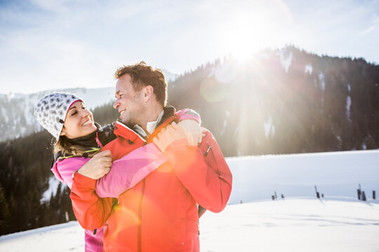 Couple hugging in snowy mountain landscape, Achenkirch, Austria - Powered by Adobe