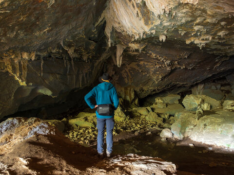 Spain, Basque Country, Euskadi, senior man viewing rocks in Baltzola cave