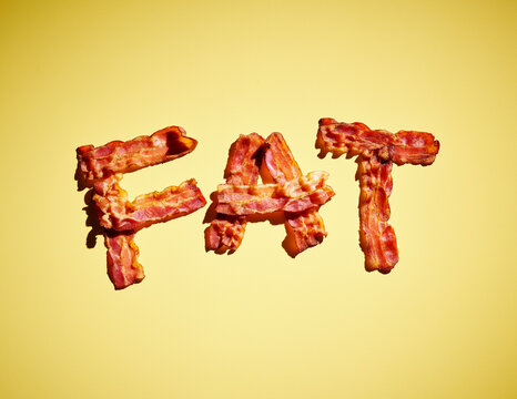 Studio shot of bacon strips arranged in word FAT