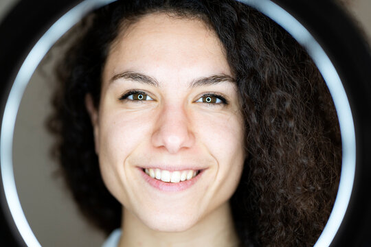 Smiling woman in front of ring light
