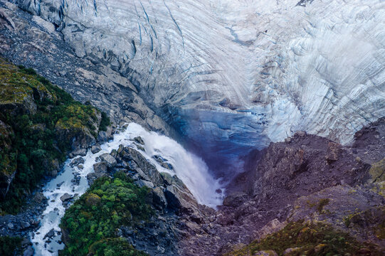 Aerial view of a waterfall falling into Fox Glacier, South Island, New Zealand