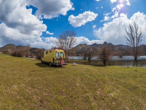 Spain, Asturias, Camposolillo, camper at Porma reservoir and Cantabrian Mountains in the back