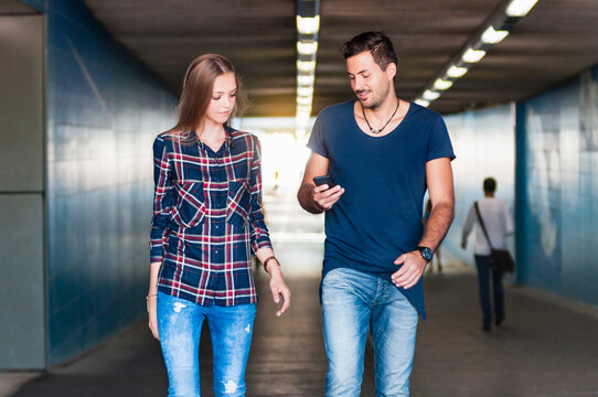 Young man and young woman walking together in an underpass