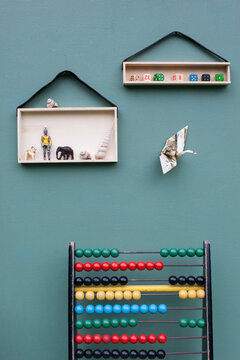 Abacus and toys on DIY shelves hanging on leather strips