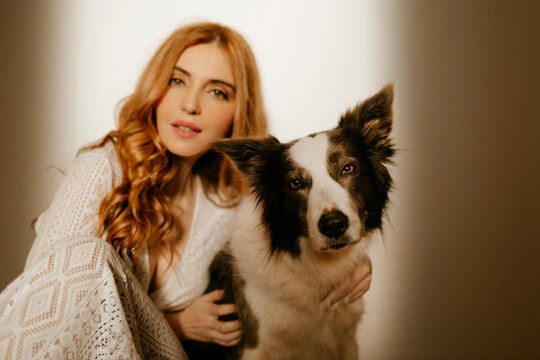 Blond woman at home in pijama with a border collie dog
