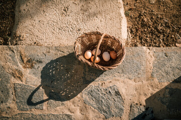 Eggs in wicker basket over stone floor