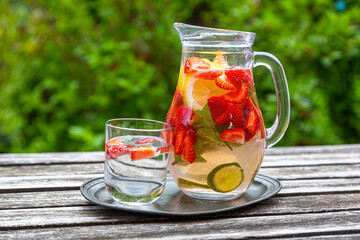 Detox water with strawberry, lime, lemon and mint in a glass jar