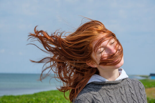 Windswept hair of a teenage girl at the coast, Skane, Sweden