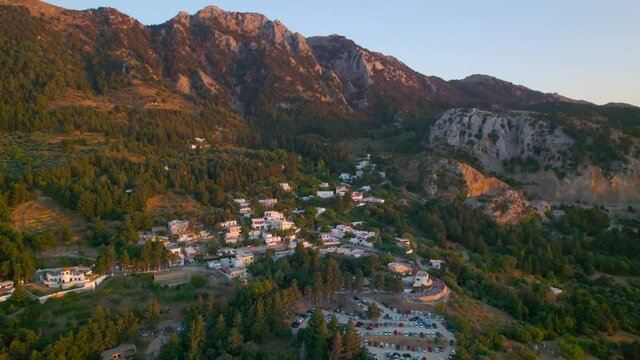 Aerial view approaching mountainside Zia village during sunset