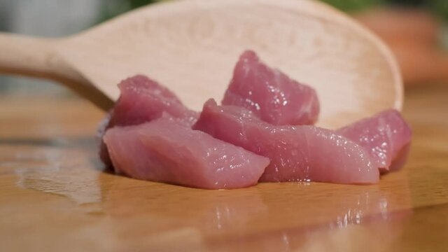 Fresh Cut Young Lamb Meat Moved By Wooden Spoon On Chopping Board. close up, slow motion