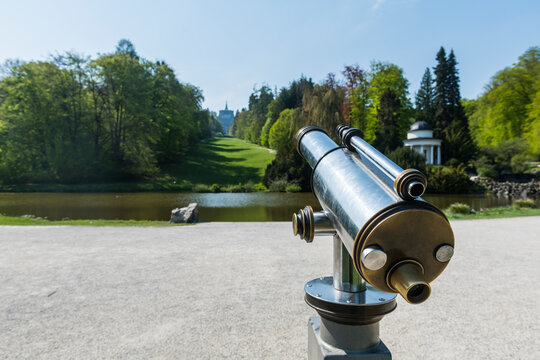 Germany, Hesse, Kassel, Coin operated binoculars in front of pond in Bergpark Wilhelmshohe
