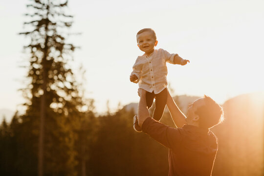 Happy father lifting up little son outdoors at sunset, Schwaegalp, Nesslau, Switzerland
