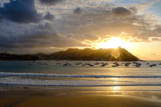 Spain, Gipuzkoa, San Sebastian, Boats floating in Bay of La Concha at cloudy sunset
