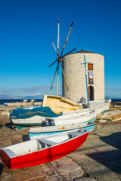 Boats moored by traditional windmill against clear blue sky in Corfu town, Ionian islands, Greece
