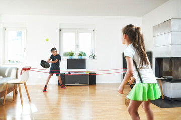 Siblings enjoying tennis at home during pandemic situation